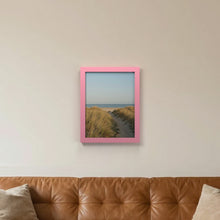 Baby Pink picture frame hanging on a living room wall