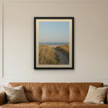 Black picture frame with an ivory mount hanging on a living room wall