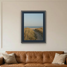 Dark Grey picture frame with a Pacific Blue mount hanging on a living room wall