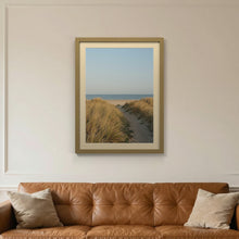 Gold picture frame with an ivory mount hanging on a living room wall
