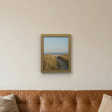 Gold picture frame hanging on a living room wall