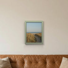 Green picture frame hanging on a living room wall