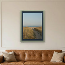 Green picture frame with a Pacific Blue mount hanging on a living room wall