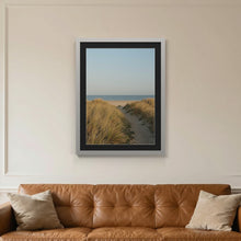 Light Grey picture frame with a black mount hanging on a living room wall