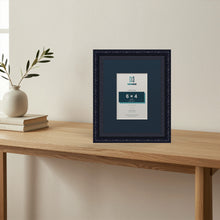 Louis Black picture frame with a Pacific Blue mount standing on a table