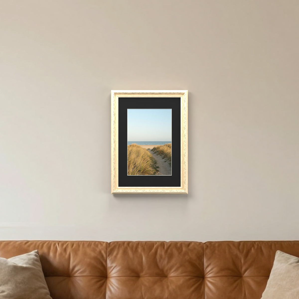 Louis Cream picture frame with a black mount hanging on a living room wall