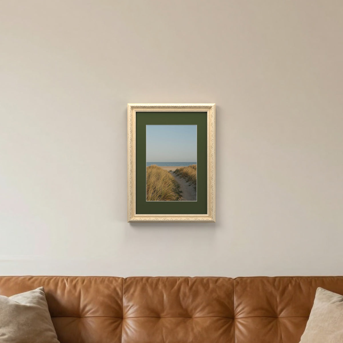Louis Cream picture frame with a green mount hanging on a living room wall