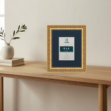 Louis Gold picture frame with a Pacific Blue mount standing on a table