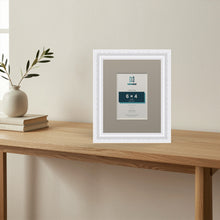 Louis White picture frame with a Dawn Grey mount standing on a table