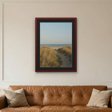 Mahogany picture frame with a black mount hanging on a living room wall