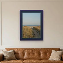 Purple picture frame with a Pacific Blue mount hanging on a living room wall