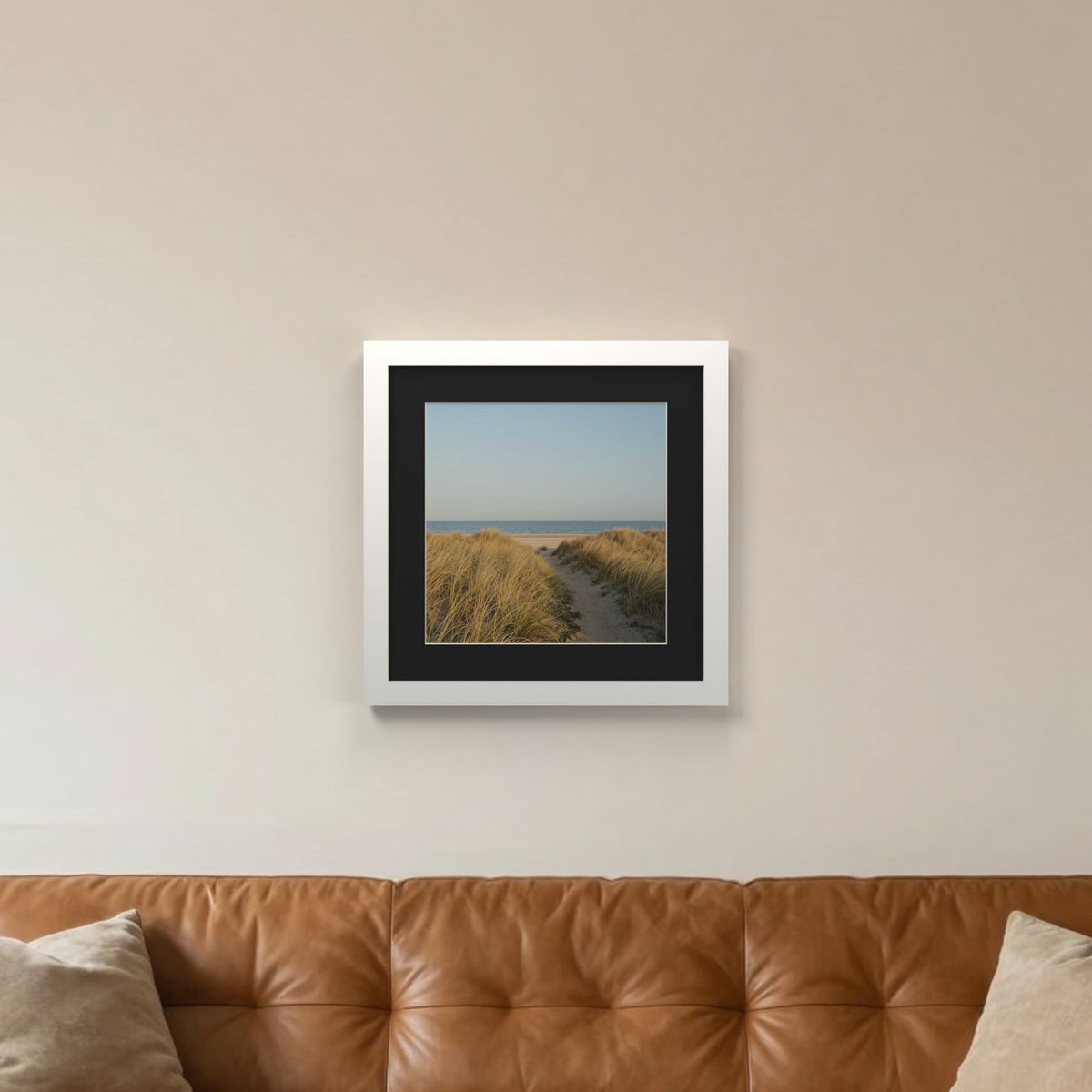 White picture frame with a black mount hanging on a living room wall