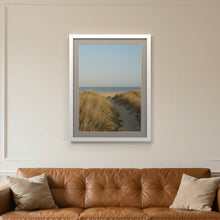 White picture frame with a Dawn Grey mount hanging on a living room wall