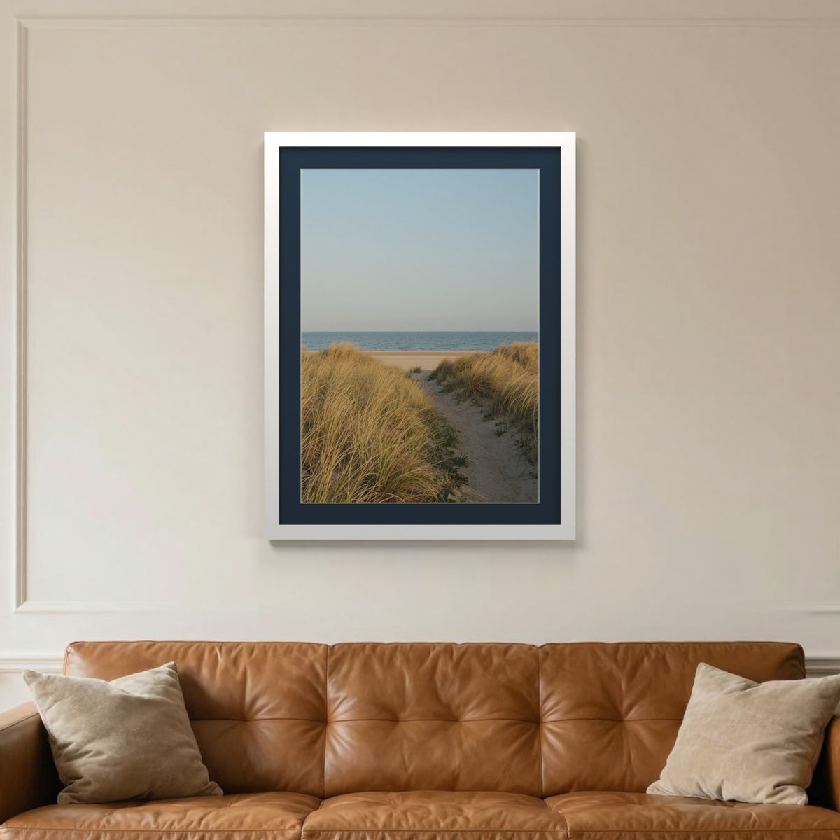White picture frame with a Pacific Blue mount hanging on a living room wall